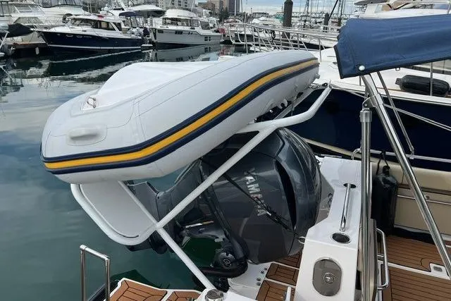 Slide: The Image of 2025 Ranger Tugs R-25 Luxury Edition with mounted inflatable boat at marina. - 5