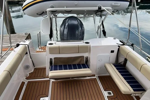 Slide: The Image of 2025 Ranger Tugs R-25 Luxury Edition boat interior with seating and wood flooring. - 7