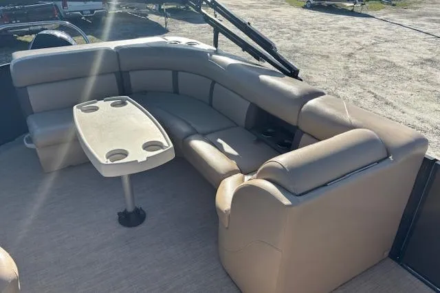 Slide: The Image of 2020 Harris Cruiser 210 boat interior with beige seating and a table. - 16
