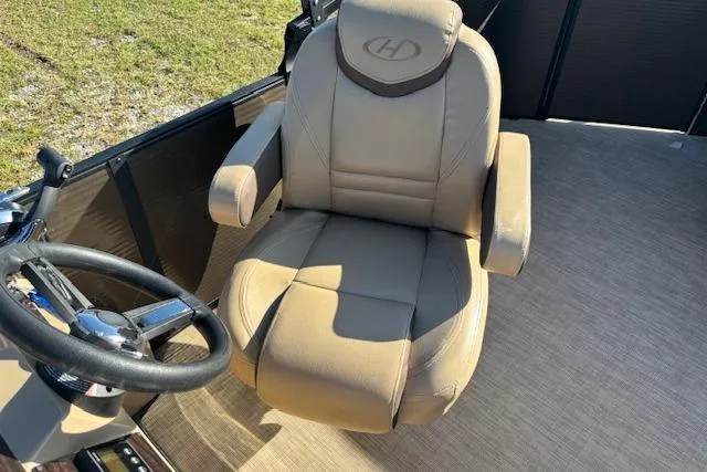 Slide: The Image of Captain's chair on 2020 Harris Cruiser 210 boat, featuring beige upholstery and steering wheel. - 22