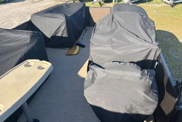 Slide: The Image of 2020 Harris Cruiser 210 boat interior with covered seats and a beige table. - 26