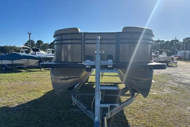 Slide: The Image of 2020 Harris Cruiser 210 pontoon boat on trailer in sunny outdoor setting. - 3