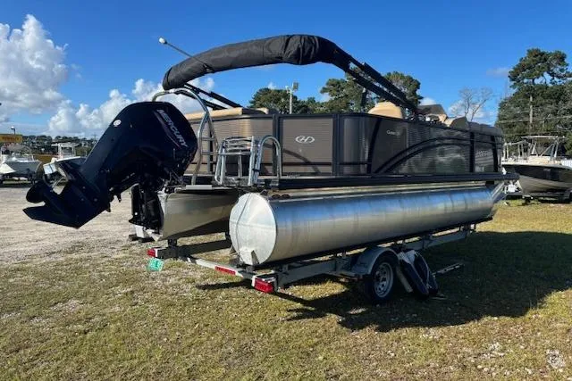 Slide: The Image of 2020 Harris Cruiser 210 pontoon boat on trailer, parked outdoors under clear sky. - 6