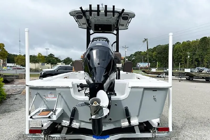 Slide: The Image of 2026 Sea Pro 230 Bay boat, rear view with outboard motor, parked outdoors. - 2