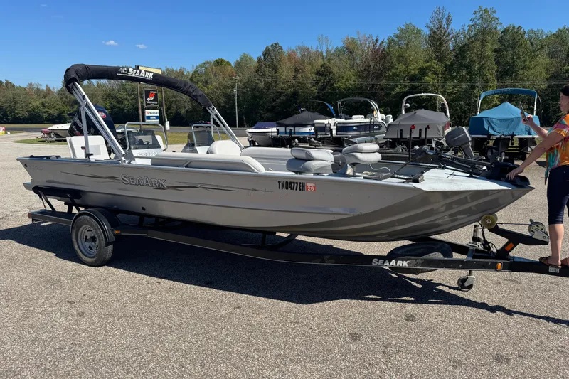 Slide: The Image of 2014 SeaArk Easy 200 boat on trailer, parked outdoors, with trees in the background. - 1