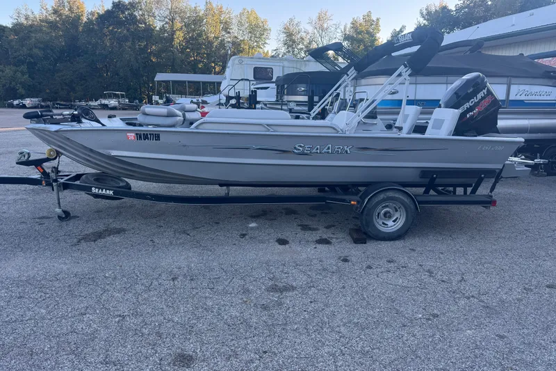 Slide: The Image of 2014 SeaArk Easy 200 boat on trailer, parked outdoors with trees in background. - 8