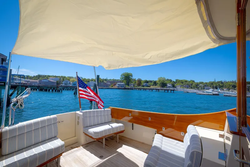 Slide: The Image of Hinckley Talaria 44 MY 2009 yacht deck with seating, American flag, and waterfront view. - 21