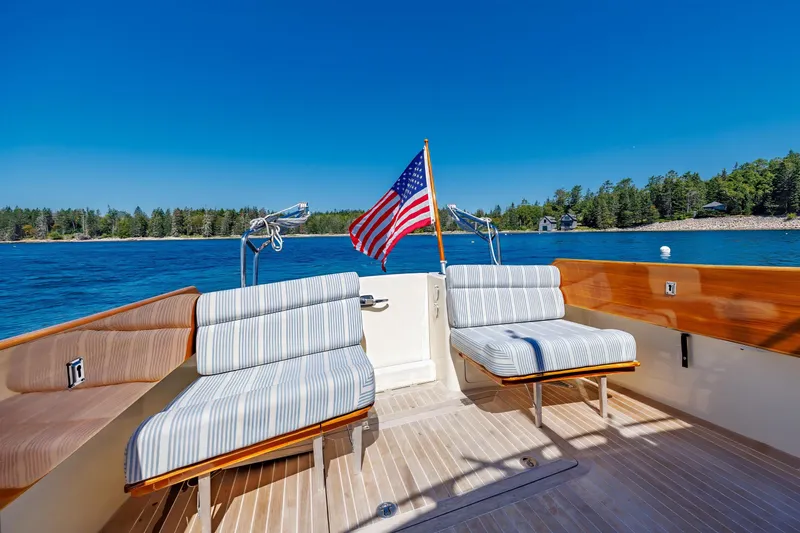 Slide: The Image of 2009 Hinckley Talaria 44 MY yacht deck with striped seating and American flag. - 23