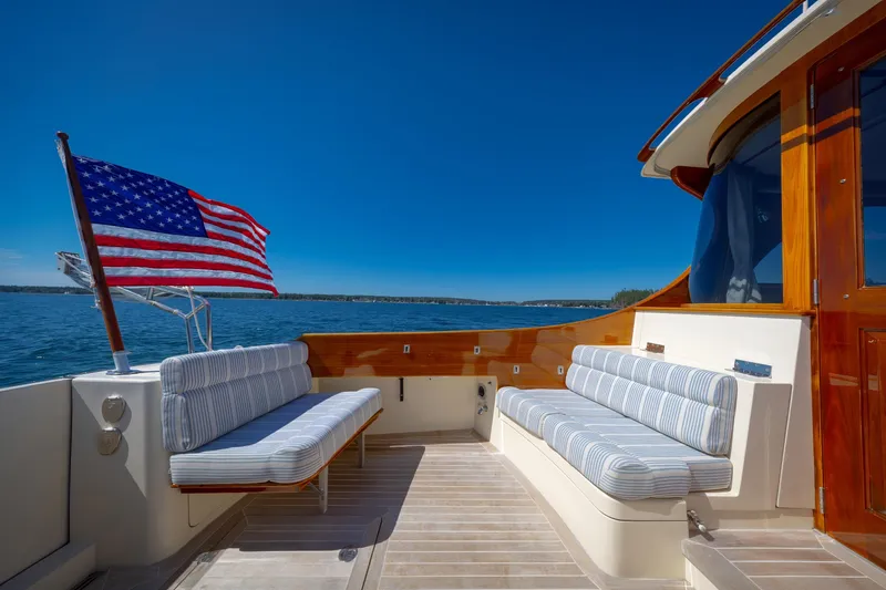 Slide: The Image of Hinckley Talaria 44 MY 2009 yacht deck with American flag and cushioned seating. - 26
