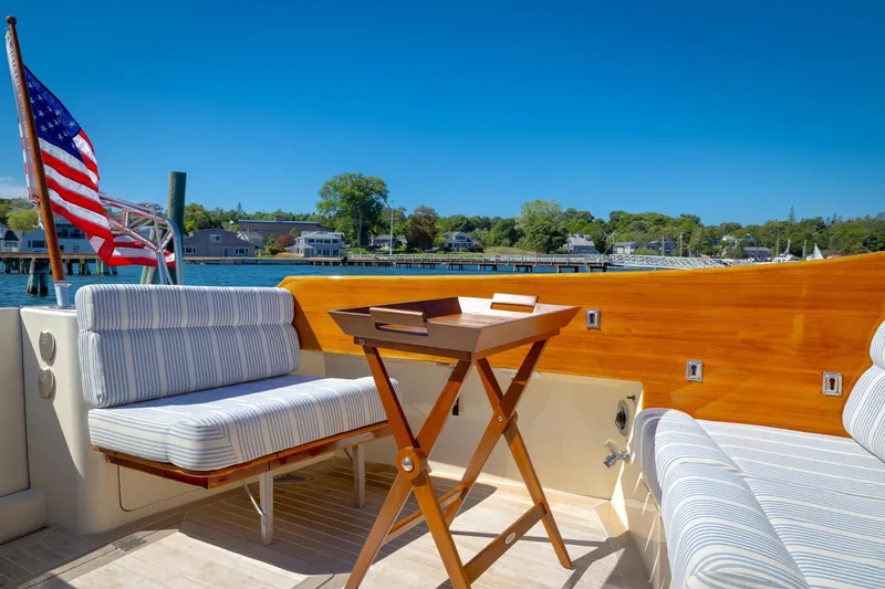 Slide: The Image of Hinckley Talaria 44 MY 2009 yacht deck with seating, table, and American flag, overlooking marina. - 27