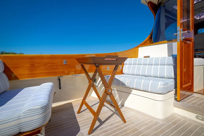 Slide: The Image of 2009 Hinckley Talaria 44 MY yacht deck with striped seating and wooden table. - 28