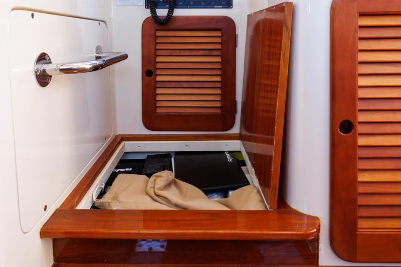 Slide: The Image of 2009 Hinckley Talaria 44 MY interior storage compartment with wooden paneling and equipment. - 43