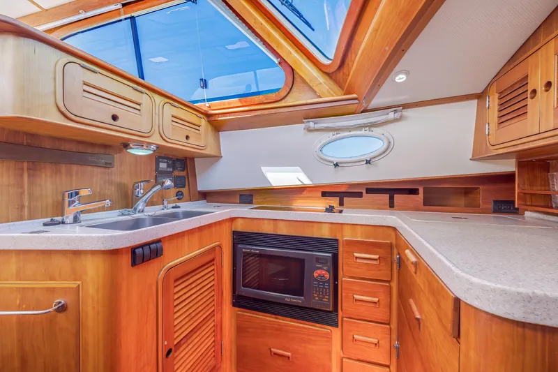 Slide: The Image of Luxurious 2009 Hinckley Talaria 44 MY yacht kitchen with wood cabinetry and modern appliances. - 46