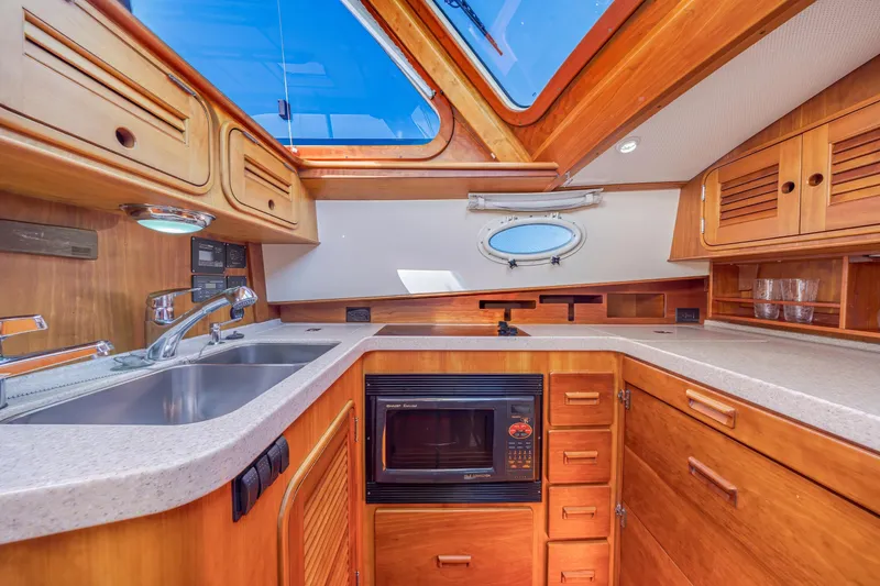 Slide: The Image of Luxurious 2009 Hinckley Talaria 44 MY yacht kitchen with wood cabinetry and modern appliances. - 47