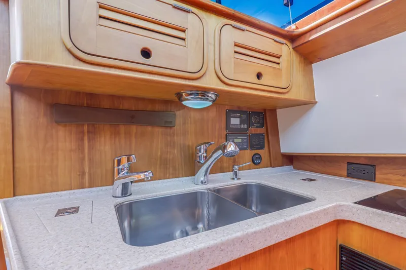 Slide: The Image of Hinckley Talaria 44 MY 2009 yacht kitchen with wooden cabinets and stainless steel sink. - 48