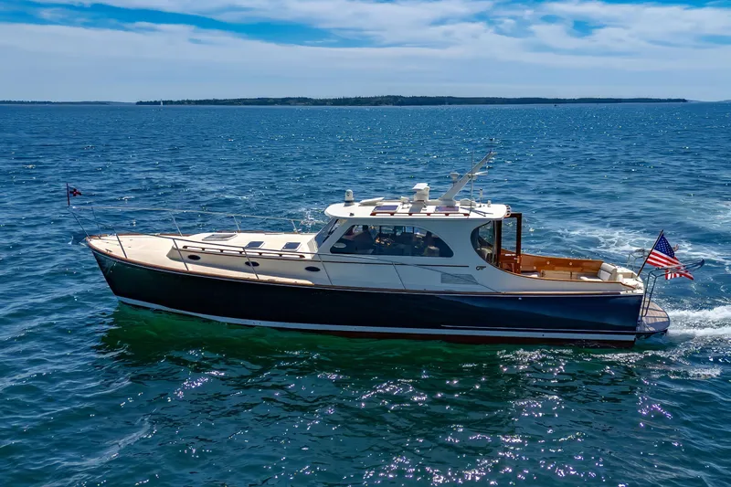 Slide: The Image of 2009 Hinckley Talaria 44 MY yacht cruising on open water under a clear blue sky. - 5