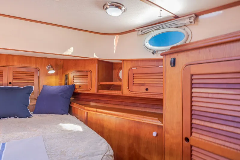 Slide: The Image of 2009 Hinckley Talaria 44 MY cabin interior with wood paneling and cozy bedding. - 60