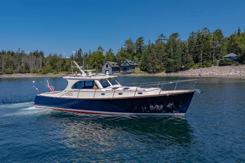 Slide: The Image of 2009 Hinckley Talaria 44 MY yacht cruising on a serene lake with forested shoreline. - 7