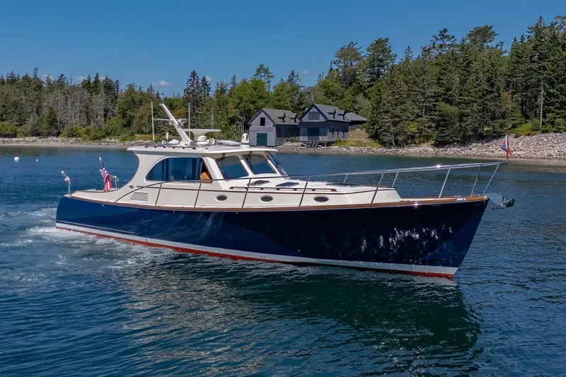 Slide: The Image of 2009 Hinckley Talaria 44 MY yacht cruising near a forested shoreline. - 8