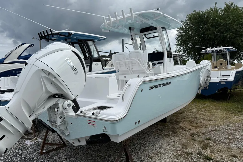 Slide: The Image of 2026 Sportsman Heritage 231 Center Console boat with Yamaha engine, parked outdoors. - 2