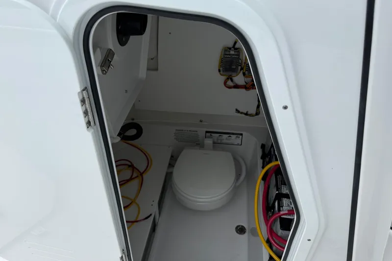 Slide: The Image of 2026 Sportsman Heritage 231 Center Console boat interior with toilet and wiring. - 9