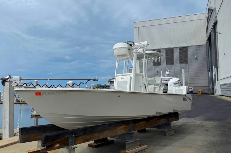 Slide: The Image of 2023 Tides 26 boat on dock, near marina, under cloudy sky. - 0
