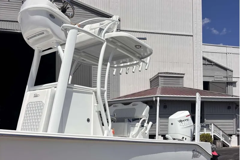Slide: The Image of 2023 Tides 26 boat with powerful engine, docked near a large warehouse. - 10