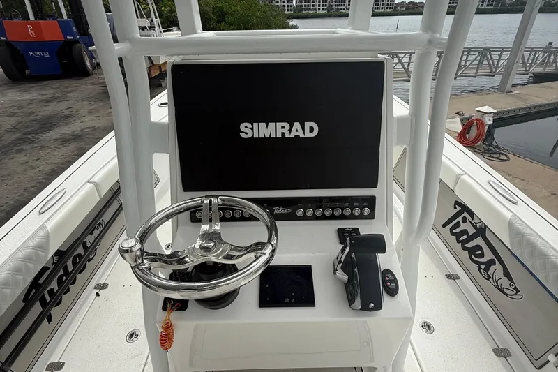 Slide: The Image of 2023 Tides 26 boat console with Simrad display and steering wheel. - 17