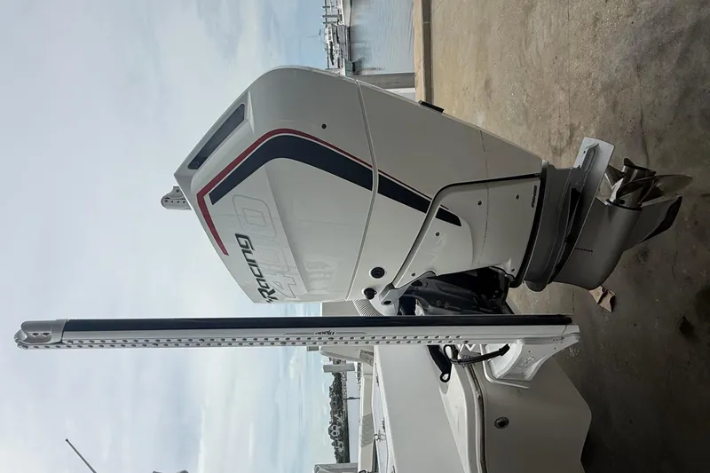 Slide: The Image of 2023 Tides 26 boat with powerful outboard motor, docked by the water. - 25