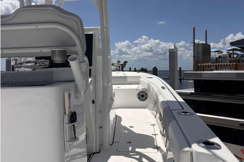 Slide: The Image of 2023 Tides 26 boat interior with seating, docked under a clear sky. - 27