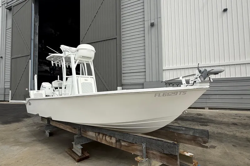 Slide: The Image of 2023 Tides 26 boat on a wooden stand outside a large warehouse. - 28
