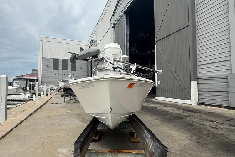 Slide: The Image of 2023 Tides 26 boat docked near a large warehouse under cloudy skies. - 29