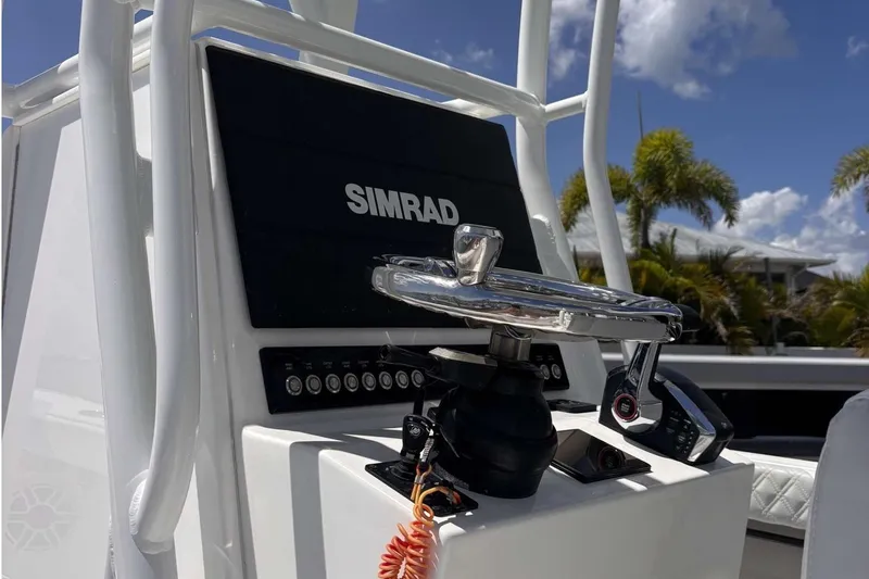 Slide: The Image of 2023 Tides 26 boat console with Simrad navigation system and steering wheel. - 3