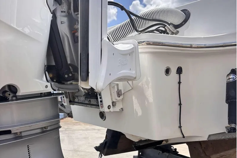 Slide: The Image of 2023 Tides 26 boat engine and transom detail under a clear sky. - 33