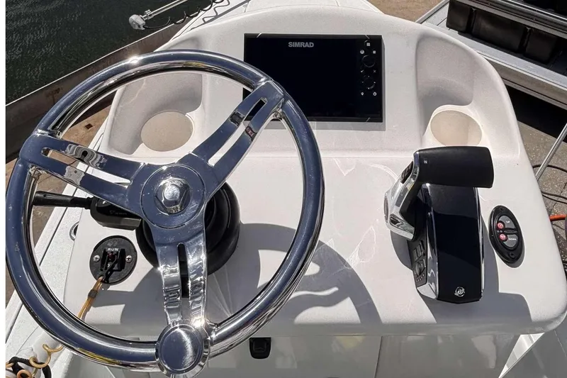 Slide: The Image of Steering console of 2023 Tides 26 boat with Simrad display and controls. - 4