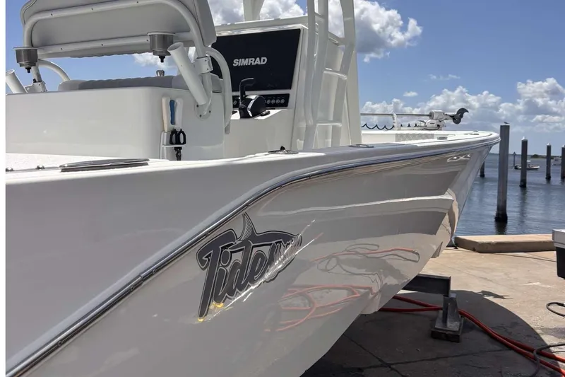 Slide: The Image of 2023 Tides 26 boat docked, featuring sleek design and Simrad electronics. - 5