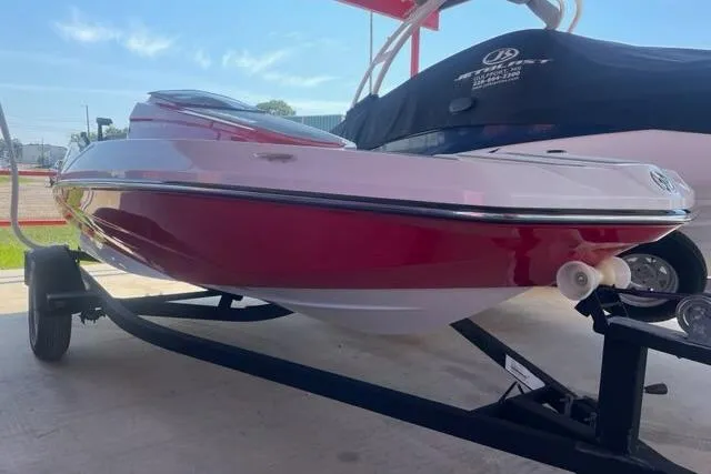 Slide: The Image of 2016 Scarab 165 G boat in red and white on a trailer. - 2