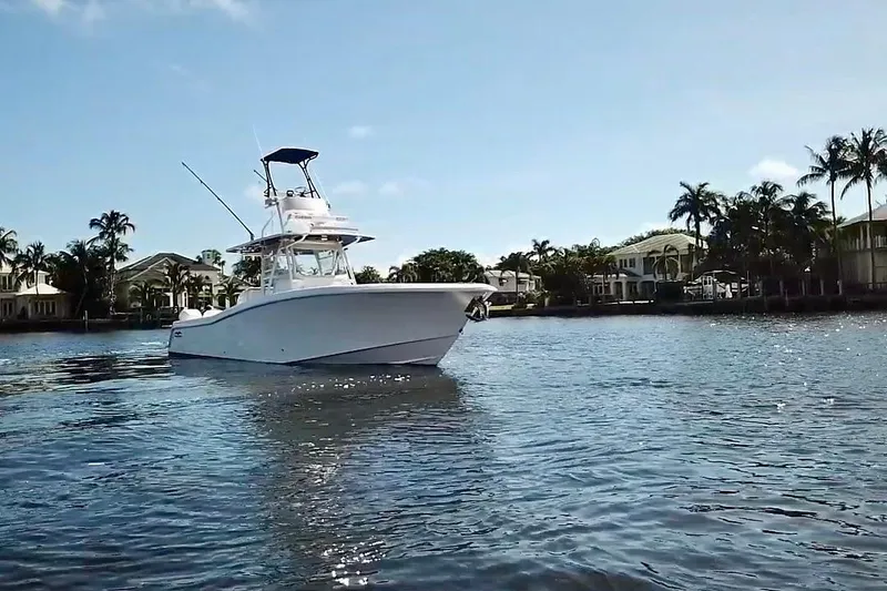 Slide: The Image of 2020 Invincible 39 Open Fisherman boat on calm water, surrounded by palm trees. - 2