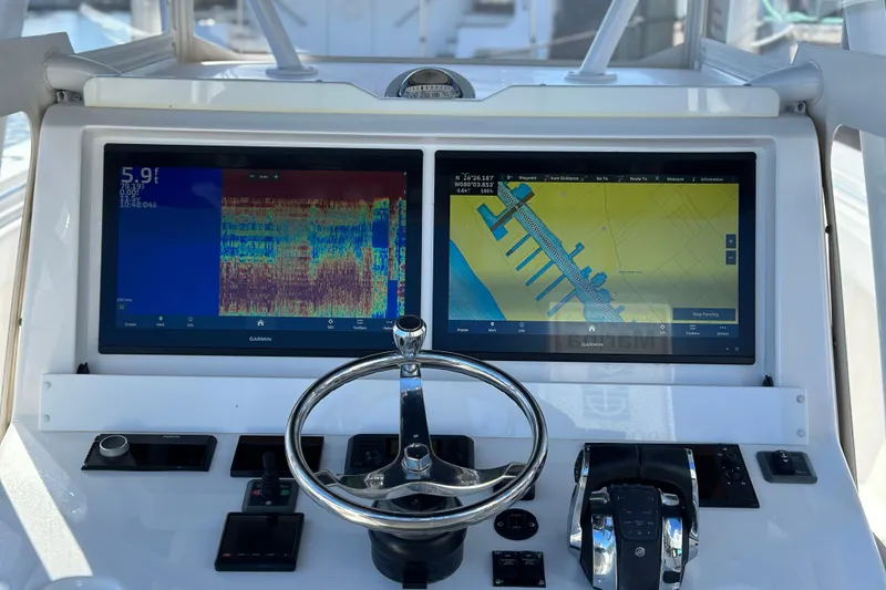 Slide: The Image of 2020 Invincible 39 Open Fisherman dashboard with dual Garmin displays and steering wheel. - 7