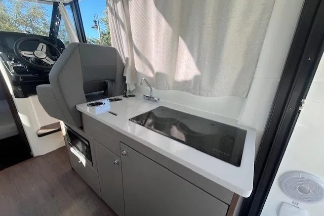 Slide: The Image of 2026 Beneteau Antares 9 V2 interior with modern kitchenette and helm station. - 21