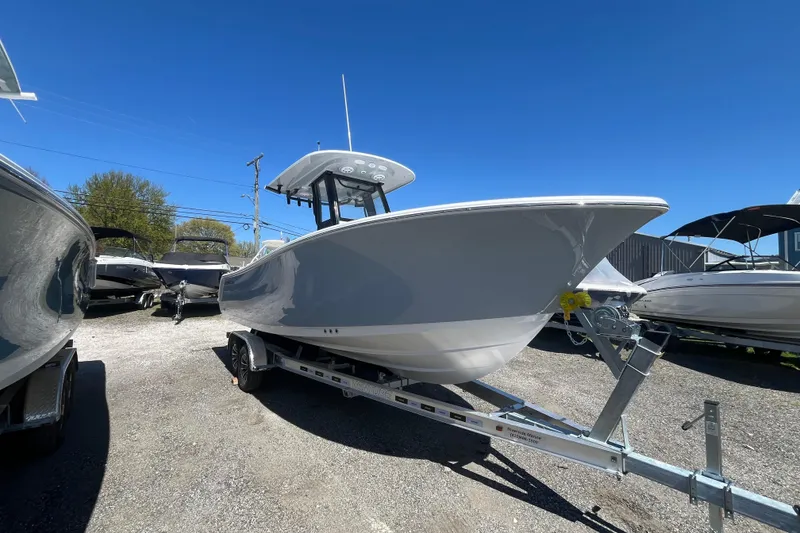 Slide: The Image of 2026 Sportsman Heritage 231 Center Console boat on trailer under clear blue sky. - 13