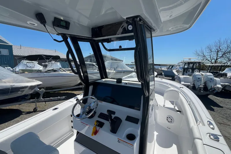 Slide: The Image of 2026 Sportsman Heritage 231 Center Console boat interior with steering wheel and controls. - 15