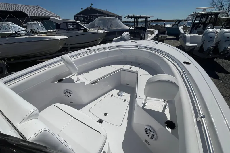 Slide: The Image of 2026 Sportsman Heritage 231 Center Console boat, sleek white interior, docked among other boats. - 17