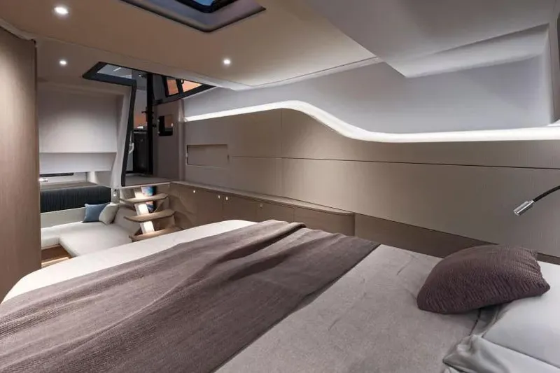 Slide: The Image of 2026 Beneteau Gran Turismo 40 yacht on serene blue waters near a rocky shoreline. - 6