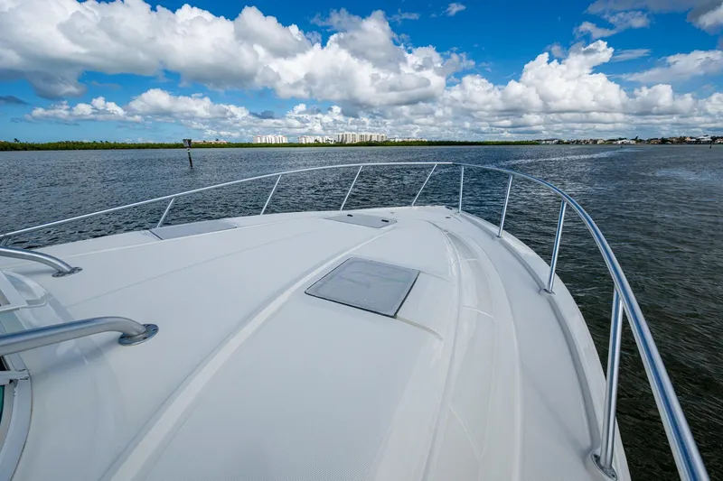 Slide: The Image of 2014 SeaVee 430 boat cruising on calm waters under a blue sky with clouds. - 19