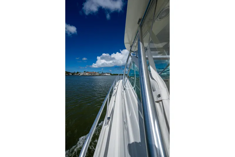 Slide: The Image of 2014 SeaVee 430 boat cruising on calm waters under a clear blue sky. - 21