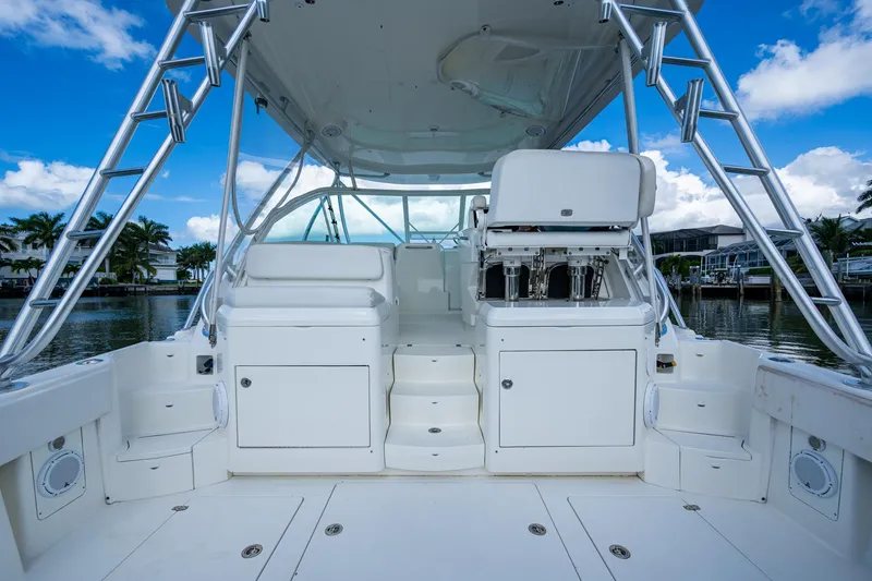 Slide: The Image of 2014 SeaVee 430 boat deck with seating, storage, and ladder under a blue sky. - 26