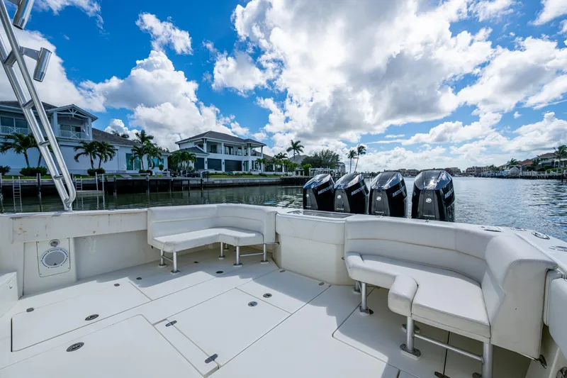 Slide: The Image of 2014 SeaVee 430 boat with spacious seating, docked by waterfront homes under a blue sky. - 32