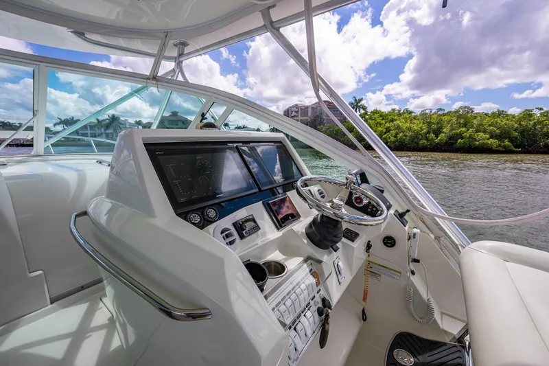 Slide: The Image of Helm of 2014 SeaVee 430 boat with modern controls and scenic waterway view. - 43