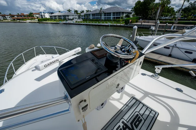 Slide: The Image of 2014 SeaVee 430 boat helm with Garmin navigation system, docked near waterfront homes. - 45